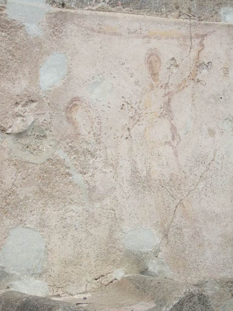 Pompeii street altar on west side wall of I.11.1. May 2006.
Remains of painting above altar. The right hand Lar can be seen with his left hand raised holding a cornucopia. A curving line flows from the cornucopia, above his head and down to the situla (bucket) in his right hand. The curve of the serpent can be seen above the top of the painted round altar.
The head is down to the left reaching into the burning offering on the top of the altar. The garland can be seen above the Lar.