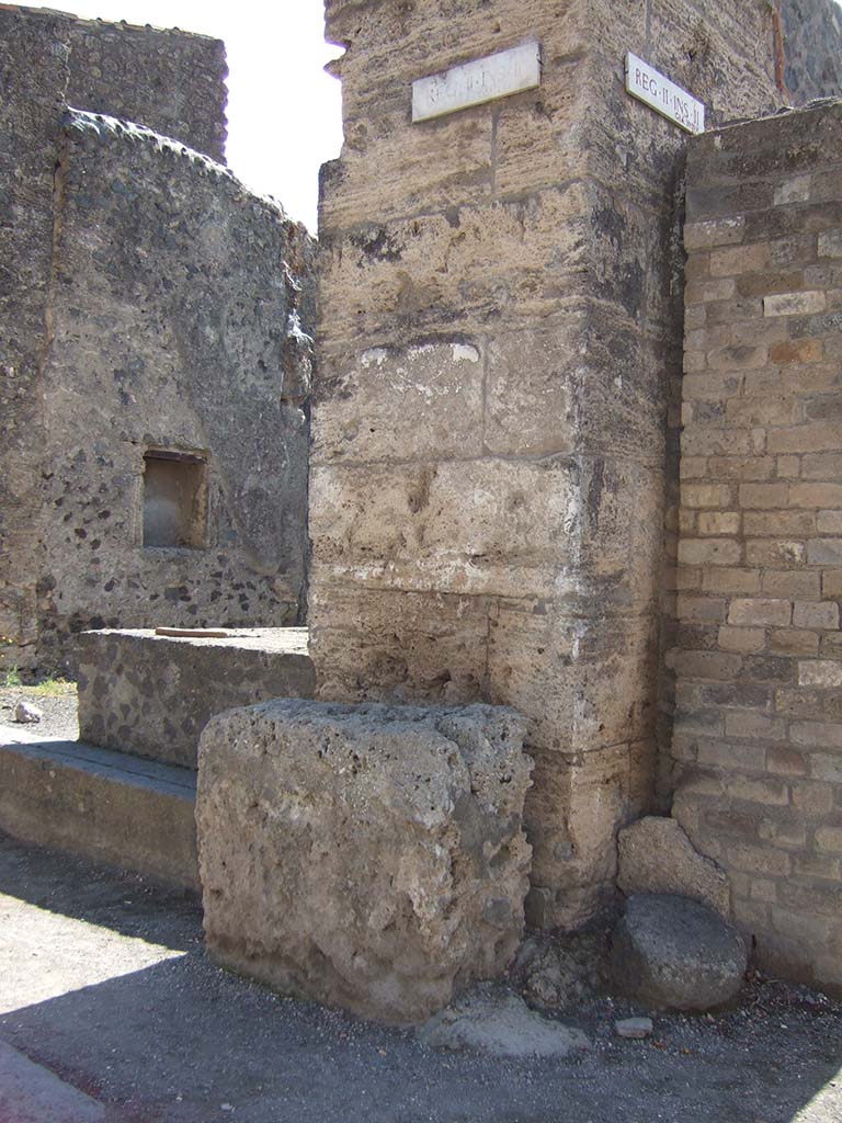 Street altar outside II.2.1 on Via dell’Abbondanza, September 2005.
According to Fröhlich (from the only source - Spinazzola), in front of the wall stood a white plastered masonry altar.
Above this, the remains of an older painting were visible through a newer lime layer.
This showed five figures, probably the vicomagistri and a tibicen, and a tablet with illegible names.
See Fröhlich, T., 1991. Lararien und Fassadenbilder in den Vesuvstädten. Mainz: von Zabern. (F17, p. 312).
