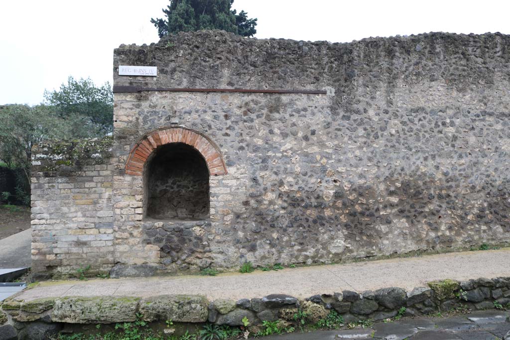 II.4.7a Pompeii. December 2018.
Exterior north-east corner of insula on south side of Via dell’Abbondanza, niche compitale. Photo courtesy of Aude Durand.