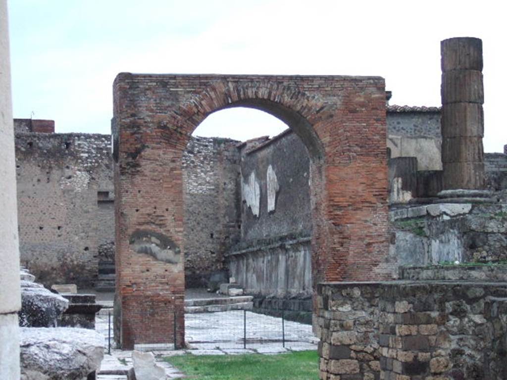 VII.8.1 Pompeii. Arch in north-west corner, showing arched niche on the south side of the rear wall. On the rear of the arched niche, is a niche altar on the north street side.