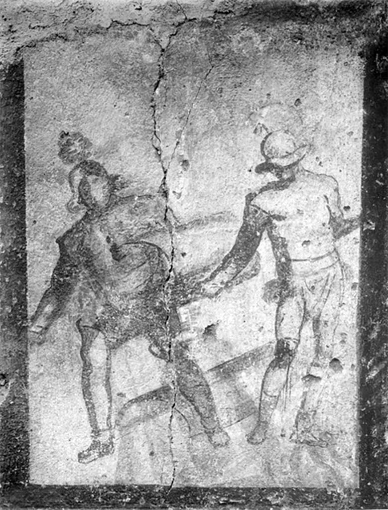 Street shrine outside IX.12.7. Detail from 1912 photograph.
Top left of the four paintings was a monochrome painting of two gladiators in combat.
According to Jacobelli, this represented the final encounter between two gladiators.
Both were armed with curved rectangular shields, helmets and armbands. One wears high boots, the other a legging and a knee guard.
The gladiator on the right had a bloody wound on his knee. Exhausted from combat, he was on the verge of collapse.
The victor, probably a Thraex (Thracian), was using his shield to ward off his opponents last feeble blow.
See Jacobelli, L., 2003. Gladiators at Pompeii. Rome: L’Erma di Bretschneider. (p. 85; Figs 69-70).