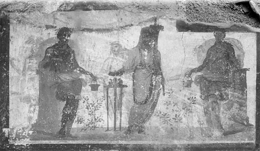Street shrine outside IX.12.7. Detail from 1912 photograph.
Top right of the four paintings was a painting of two Lares in green tunics leaning on pillars.
A genius was making a sacrifice at a portable altar.
Three other similar people from an older picture were also visible through the white background.
See Fröhlich, T., 1991. Lararien und Fassadenbilder in den Vesuvstädten. Mainz: von Zabern. (p. 339, F71, T: 58,2).
