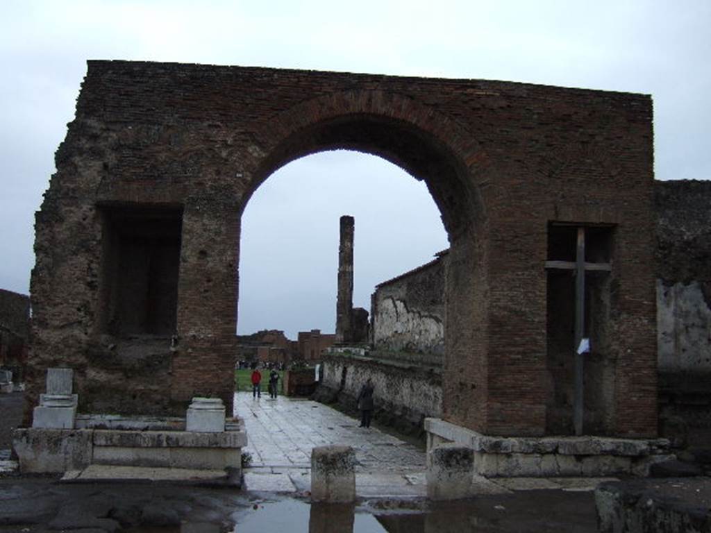Arch at North East End of the Forum. December 2005. North side with fountains. Looking south-west through arch from Via del Foro.