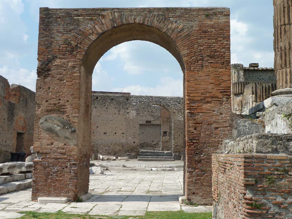 Arched entrance in north-west corner of Pompeii Forum, May 2010.
Looking north through Arch of Augustus to the arched entrance with its steps.