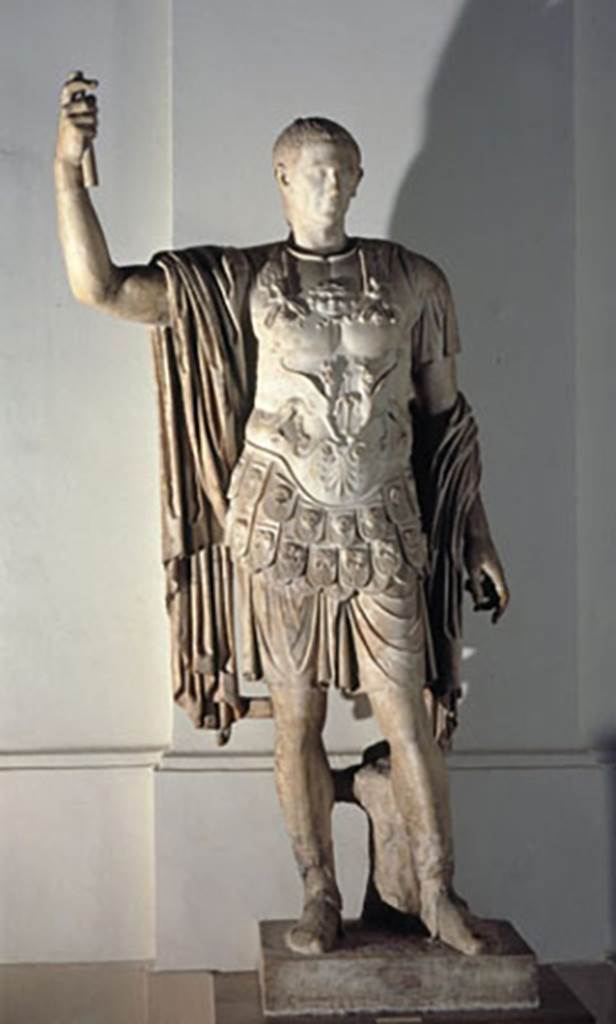 Arch of Marcus Holconius Rufus. Marble statue of Marcus Holconius Rufus.
Now in Naples Archaeological Museum. Inventory number 6233.
According to Cooley, Marcus Holconius Rufus was of equestrian rank, but his statue appropriated status symbols more correctly belonging to others.
He was in military dress even though he did not actually serve in the army in his role.
He was depicted wearing the sandals of a senator.
Colouring was visible when the statue was first found in 1853.
His tunic was white edged with yellow, his cloak red and his shoes black.
The tree trunk supporting the statue was green. His hair, eyes and eyebrows were also coloured.
See Cooley, A. and M.G.L., 2004. Pompeii: A Sourcebook. London: Routledge. (Page 128, F89).