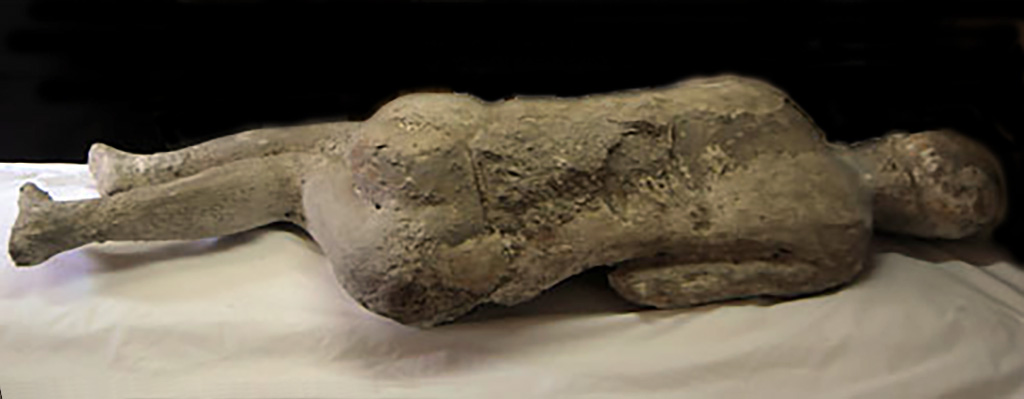 Victim 63. A young woman lying on her right side, almost curled up.
Victim 63 was found outside Porta Nola, near the tomb of M. Obellius Firmus, between the 2nd of August and the 21st of September 1976.
The victim is a female aged between 13 and 19 years.
On the shoulders, chest, and on the sides, the drapery of the clothing can be distinguished.
See Osanna, N., Capurso, A., e Masseroli, S. M., 2021. I Calchi di Pompei da Giuseppe Fiorelli ad oggi: Studi e Ricerche del PAP 46, p. 467-8, Calco n. 63.