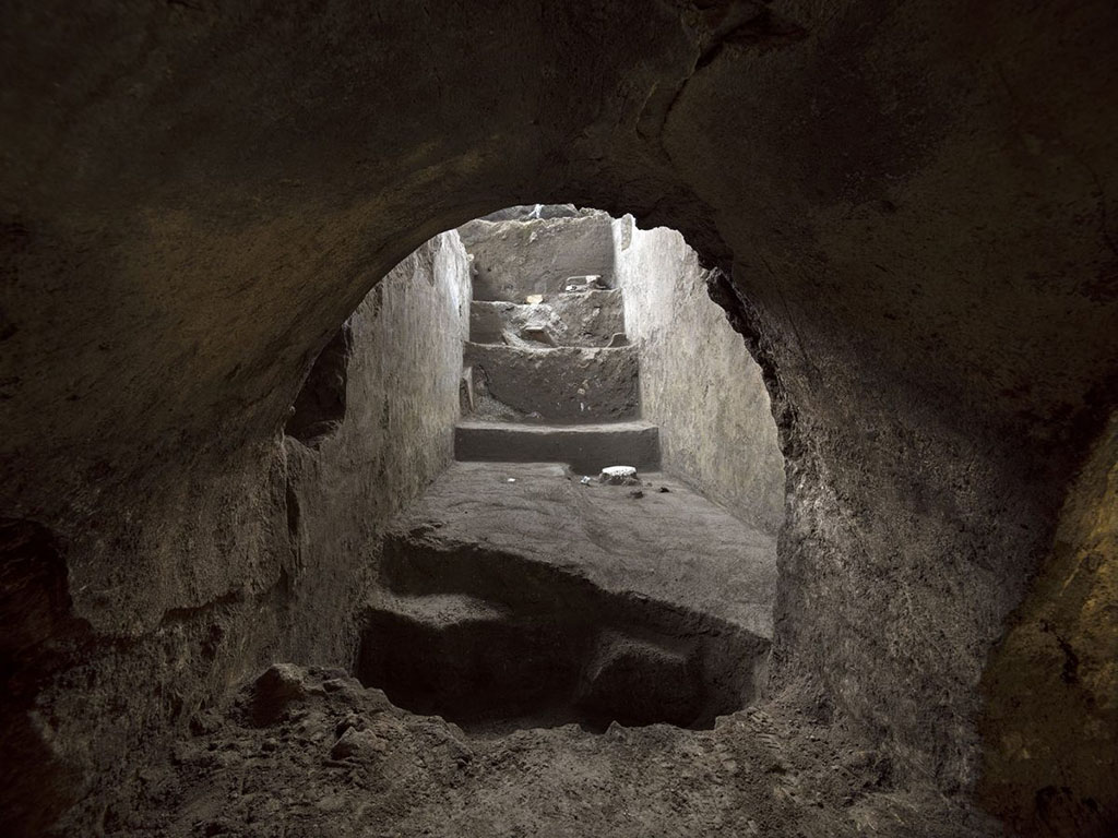 November 2020. Side room of the cryptoporticus, in the form of a passageway below the villa which led to the upper floor.
This space, 2.2 metres wide but of a length which has yet to be determined, featured a wooden floor, as indicated by the presence of six holes in the walls for housing the beams which supported a gallery. The room was destroyed by the collapse of the highest parts of the masonry, beneath which was found a thick layer formed from the succession of pyroclastic currents that were typical of the eruption of AD 79.
Novembre 2020. I corpi sono stati individuati in un vano laterale del criptoportico, corridoio di passaggio sottostante della villa, che consentiva l'accesso al piano superiore.
Questo spazio, largo 2,2 metri ma di lunghezza ancora da determinare, presentava un pavimento in legno, come indicato dalla presenza di sei fori nelle pareti per ospitare le travi che sostenevano una galleria. La stanza fu distrutta dal crollo delle parti più alte della muratura, sotto la quale fu trovato uno spesso strato formato dalla successione di correnti piroclastiche tipiche dell'eruzione del 79 d.C.
Photograph © Parco Archeologico di Pompei.