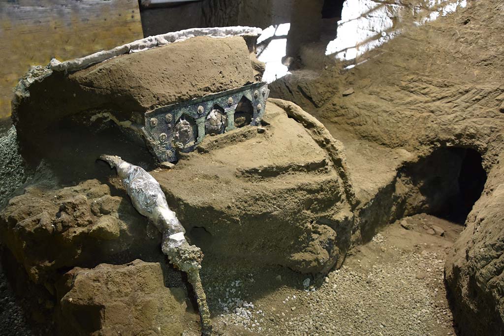 Cività Giuliana. February 2021. The four-wheeled processional chariot which has emerged intact from the excavation of the suburban villa of Cività Giuliana.
A large ceremonial chariot with four wheels, along with its iron components, beautiful bronze and tin decorations, mineralised wood remains and imprints of organic materials (from the ropes to the remains of floral decoration), has been discovered almost intact in the portico facing the stable where, in 2018, the remains of 3 equidae, including a horse still in its harness, had already been found.
This is an exceptional discovery, not only because it adds an additional element to the history of this dwelling and the story of the last moments in the lives of those who lived in it, as well as more generally to our understanding of the ancient world, but above all because it represents a unique find - which has no parallel in Italy thus far - in an excellent state of preservation.
Cività Giuliana. Febbraio 2021. Il Carro da parata a quattro ruote emerso integro dallo scavo della villa suburbana in località Civita Giuliana.
Un grande carro cerimoniale a quattro ruote, con i suoi elementi in ferro, le bellissime decorazioni in bronzo e stagno, i resti lignei mineralizzati, le impronte degli elementi organici (dalle corde a resti di decorazioni vegetali), è stato rinvenuto quasi integro nel porticato antistante alla stalla dove già nel 2018 erano emersi i resti di 3 equidi, tra cui un cavallo bardato.
Un ritrovamento eccezionale, non solo perché aggiunge un elemento in più alla storia di questa dimora, al racconto degli ultimi istanti di vita di chi abitava la villa, e più in generale alla conoscenza del mondo antico, ma soprattutto perché restituisce un reperto unico - mai finora rinvenuto in Italia – in ottimo stato di conservazione.
Photograph © Parco Archeologico di Pompei.