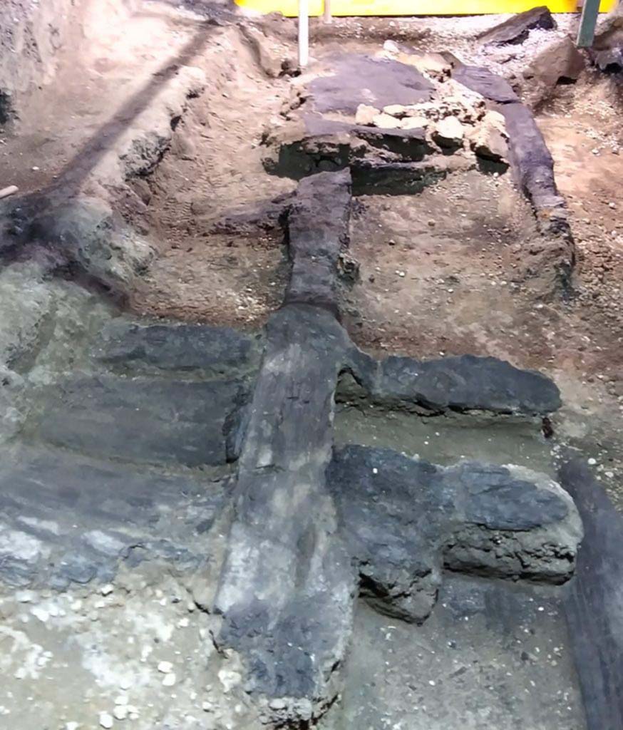 Cività Giuliana. February 2021.
An excavation was subsequently carried out which reached a depth of 6 metres relative to the road level, with stabilisation both of the excavation fronts and the robust masonry structures - which were preserved up to a level of 4 metres - that emerged over the course of the investigations.
From the very beginning, the excavation of the room where the chariot was found revealed its exceptional nature: the area in question is in fact a double-level portico which opens onto an uncovered courtyard, and which features the carbonised wooden ceiling with its network of beams, preserved in its entirety.
Archaeobotanical analyses have been carried out on the wood, which have shown that the ceiling was constructed of deciduous oak wood (Quercus sp. – cf. robur - English oak), a timber which was frequently used in the Roman age for structural elements. The carbonised wooden structure of the door on the southern side of the room, which connected the portico to the stable where the three equids were recently discovered, was also preserved, and upon analysis was identified as beechwood.
The wooden ceiling was carefully consolidated, cleaned, and removed from the excavation area in order to permit the investigations to continue.
Cività Giuliana. Febbraio 2021.
Si è quindi proceduto ad uno scavo che ha raggiunto i 6 metri di profondità rispetto al piano stradale, mettendo in sicurezza sia i fronti di scavo che le possenti strutture murarie – conservate fino a 4 m. - che emergevano nel corso delle indagini
Lo scavo dell’ambiente dove si è rinvenuto il carro ha mostrato fin dall’inizio la sua eccezionalità: si tratta infatti di un portico a due piani, aperto su una corte scoperta, che conservava in tutta la sua interezza il solaio ligneo carbonizzato con il suo ordito di travi.
Si sono condotte analisi archeobotaniche del legno che hanno mostrato come il solaio fosse stato realizzato in legno di quercia decidua (Quercus sp. – cfr. robur - farnia), un legno frequentemente utilizzato in età romana per realizzare elementi strutturali. Anche la porta sul lato sud della stanza, che metteva in comunicazione il portico con la stalla dove negli scorsi anni si sono rinvenuti 3 equidi, conservava la sua struttura in legno carbonizzato che è stato analizzato e identificato come faggio.
Il solaio ligneo è stato accuratamente consolidato, pulito e rimosso dall’area di scavo per permettere il proseguimento delle indagini.
Photograph © Parco Archeologico di Pompei.