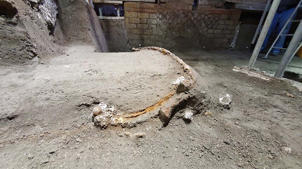 Cività Giuliana. February 2021. The excavation, which proceeded slowly over the following weeks due to the fragility of the elements which were progressively emerging, unearthed a ceremonial chariot, which had miraculously been spared by both the collapse of the walls and ceiling of the room and by the illegal activities, with tunnels passing it by on two sides, but without compromising the structure.
From the moment it was identified, the excavation of the chariot has proved to be particularly complex due to the fragility of the materials involved and the difficult working conditions; as a result, it was necessary to proceed by means of a micro-excavation conducted by the restorers of the Park, who are specialised in the treatment of wood and metals. At the same time, whenever a void was discovered, plaster was poured in as part of an attempt to preserve the imprint of the organic material that was no longer present. Consequently, it has been possible to preserve the shaft and platform of the chariot, as well as the imprints of ropes, thus revealing the chariot in all of its complexity.
Cività Giuliana. Febbraio 2021. Lo scavo proseguito lentamente nelle settimane successive – per la fragilità degli elementi che si progressivamente emergevano, ha portato alla luce un carro cerimoniale, risparmiato miracolosamente sia dai crolli delle murature e delle coperture dell’ambiente sia dalle attività clandestine, che con lo scavo di due cunicoli lo hanno sfiorano su due lati, senza averne compromessa la struttura.
Sin dal momento della sua individuazione lo scavo del carro si è rivelato particolarmente complesso per la fragilità dei materiali e le difficili condizioni di lavoro; si è quindi dovuto procedere con un vero e proprio microscavo condotto dalle restauratrici del Parco specializzate nel trattamento del legno e dei metalli. Parallelamente, ogni volta che si rinveniva un vuoto, è stato colato del gesso per tentare di preservare l’impronta del materiale organico non più presente. Così si è potuto conservare il timone e il panchetto del carro, ma anche impronte di funi e cordami, restituendo così il carro nella sua complessità.
Photograph © Parco Archeologico di Pompei.