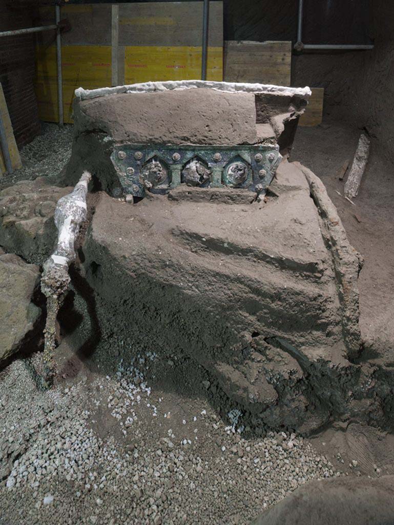 Cività Giuliana. February 2021. “It is an extraordinary discovery for the advancement of our knowledge of the ancient world”, declared Massimo Osanna, outgoing Director of the Archaeological Park, “At Pompeii vehicles used for transport have been found in the past, such as that of the House of Menander, or the two chariots discovered at Villa Arianna (one of which can be admired at the new Stabian Antiquarium), but nothing like the Cività Giuliana chariot.
What we have is a ceremonial chariot, probably the Pilentum referred to by some sources, which was employed not for everyday use or for agricultural transport, but to accompany community festivities, parades and processions. This type of chariot, which has never before emerged from Italian soil, bears comparison with finds uncovered around fifteen years ago inside a burial mound in Thrace (in northern Greece, near the Bulgarian border). One of the Thracian chariots is particularly similar to ours, even if it lacks the extraordinary figurative decorations that accompany the Pompeian find.
The scenes on the medallions which embellish the rear of the chariot refer to Eros (Satyrs and nymphs), while the numerous studs feature erotes. Considering that the ancient sources allude to the use of the Pilentum by priestesses and ladies, one cannot exclude the possibility that this could have been a chariot used for rituals relating to marriage, for leading the bride to her new household.
Cività Giuliana. Febbraio 2021. “E’ una scoperta straordinaria per l'avanzamento della conoscenza del mondo antico. – dichiara Massimo Osanna, Direttore uscente del Parco archeologico - A Pompei sono stati ritrovati in passato veicoli per il trasporto, come quello della casa del Menandro, o i due carri rinvenuti a Villa Arianna (uno dei quali si può ammirare nel nuovo Antiquarium Stabiano), ma niente di simile al carro di Civita Giuliana.
Si tratta infatti di un carro cerimoniale, probabilmente il Pilentum noto dalle fonti, utilizzato non per gli usi quotidiani o i trasporti agricoli, ma per accompagnare momenti festivi della comunità, parate e processioni. Mai emerso dal suolo italiano, il tipo di carro trova confronti con reperti rinvenuti una quindicina di anni fa all’interno di un tumulo funerario della Tracia (nella Grecia settentrionale, al confine con la Bulgaria). Uno dei carri traci è particolarmente vicino al nostro anche se privo delle straordinarie decorazioni figurate che accompagnano il reperto pompeiano.
Le scene dei medaglioni che impreziosiscono il retro del carro rimandano all'eros (Satiri e ninfe), mentre le numerose borchie presentano eroti. Considerato che le fonti antiche alludono all’uso del Pilentum da parte di sacerdotesse e signore, non si esclude che potesse trattarsi di un carro usato per rituali legati al matrimonio, per condurre la sposa nel nuovo focolare domestico.
Photograph © Parco Archeologico di Pompei.