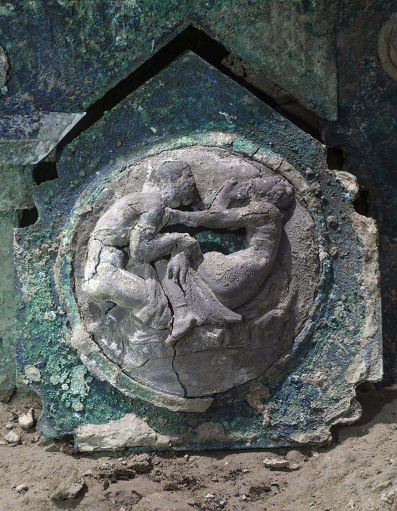 Cività Giuliana. February 2021.
These medallions, set in bronze sheet and surrounded by decorative motifs, represent male and female figures in relief, depicted in erotic scenes.
Cività Giuliana. Febbraio 2021.
Questi, incastonati nelle lamine bronzee e contornati da motivi decorativi in esse ricavati, rappresentano figure maschili e femminili a rilievo ritratte in scene a sfondo erotico.
Photograph © Parco Archeologico di Pompei.