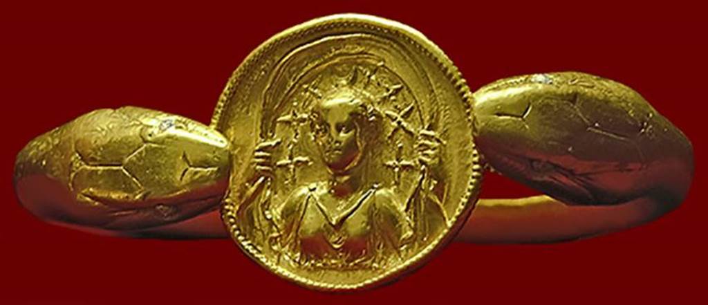 VI.17.42 Pompeii. Golden bracelet found on the arm of a woman.
According to Barbara McManus, this remarkable bracelet, 610 grams (21.5 oz) of solid gold, is fashioned in the form of two snakes flanking a round disk with a carved relief of Selene with crescent moon and stars above her head. 
It was found on the arm of a woman carrying a casket containing 40 aurei and 180 denarii. 
She was killed along with another adult and a child when a balcony collapsed in the house.
Photo courtesy of Barbara McManus. See The VRoma Project 
Now in Naples Archaeological Museum. Inventory number 14268.
According to recent DNA analysis in 2024, the victim sporting the bracelet was actually found to be a dark-haired, dark-skinned male and he has no relation to the two infant boys found with him. 

