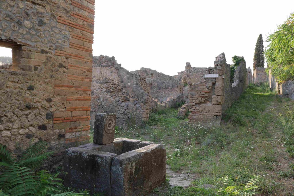 Fountain at 1.5.2, Pompeii. September 2018.
Looking north-west across fountain towards entrance doorway of I.2.23 on Vicolo del Conciapelle. Photo courtesy of Aude Durand.