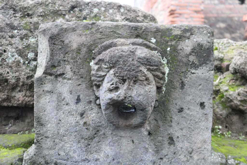 Fountain outside I.13.10, possibly representing head of Juno or a nymph, with diadem. December 2018. Photo courtesy of Aude Durand.