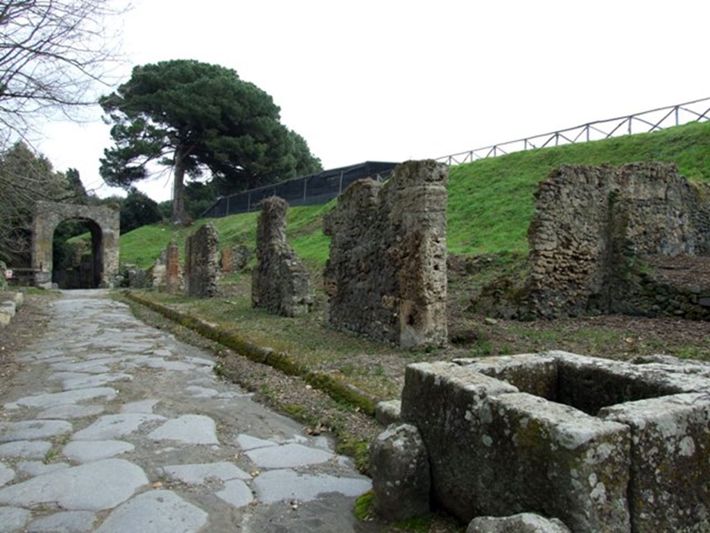 Fountain III.11.1 Pompeii. March 2009. Via di Nola looking east to Nola Gate, taken from outside III.11.1 and fountain.
Eschebach numbers this as III.12.f. CTP rejects this and refers to the insula as being III.11 (A to H).
The insula is shown on the World of Pompeii maps as III.11.1-7 and a. The fountain is now at III.11.1.
See Eschebach, H., 1983. Pompeii, Herculaneum, Stabiae; Bollettino dell’Associazione Internazionale Amici di Pompei 1, p. 12, Kat. Nr. 10.
See Van der Poel, H. B., 1986. Corpus Topographicum Pompeianum, Part IIIA. Austin: University of Texas, p. 66 and 85.
See Dobbins, J. J. and Foss, P. W., 2008. The World of Pompeii. Oxford: Routledge. CD with map.