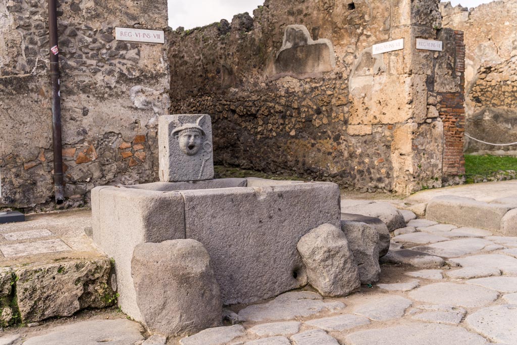 Fountain outside VI.8.24, Pompeii. January 2023.
Looking north-west from Via di Mercurio towards junction with Vicolo di Mercurio, at rear of fountain. Photo courtesy of Johannes Eber.