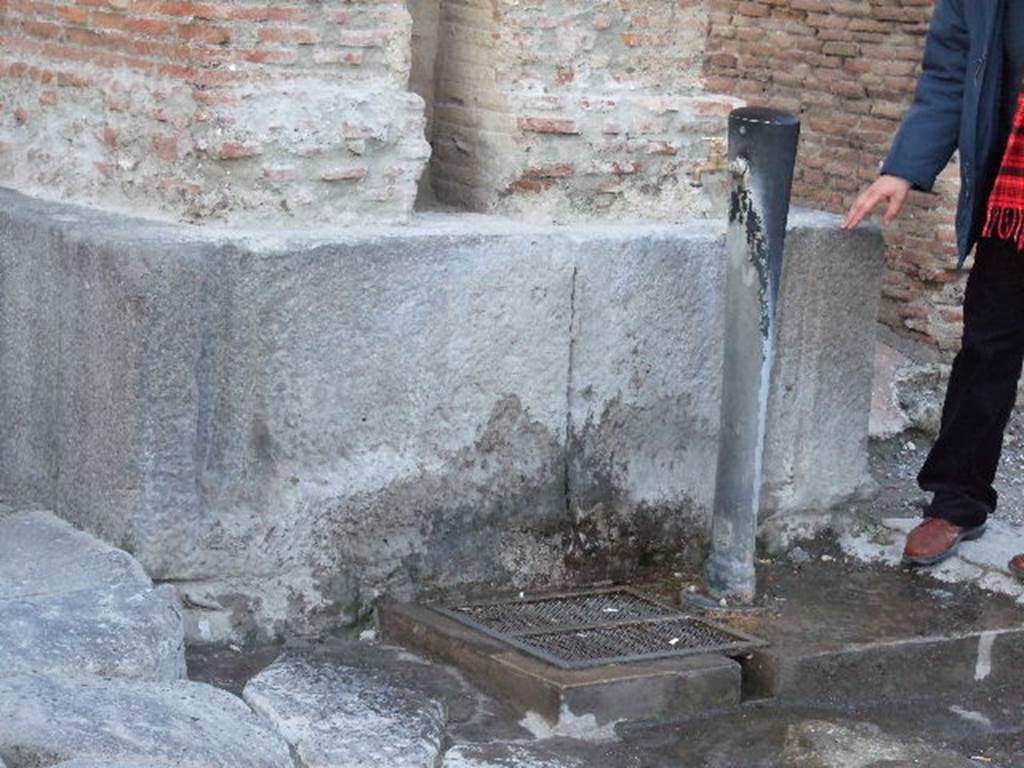 Drinking fountain at base of Arch of Caligula on Via Mercurio at VI.10.10. December 2006.
The junctions of the original fountain basins can be seen.