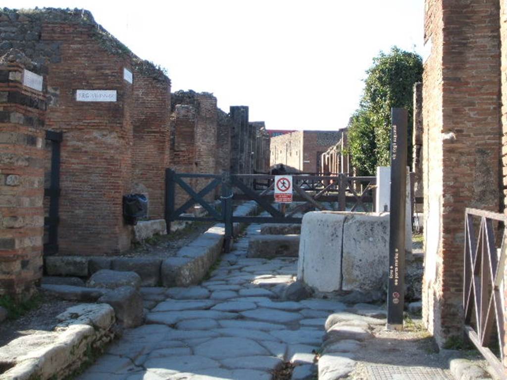 Fountain outside VII.4.32 on Via degli Augustali. December 2004. Looking west from crossroads with Vicolo Storto, on right.