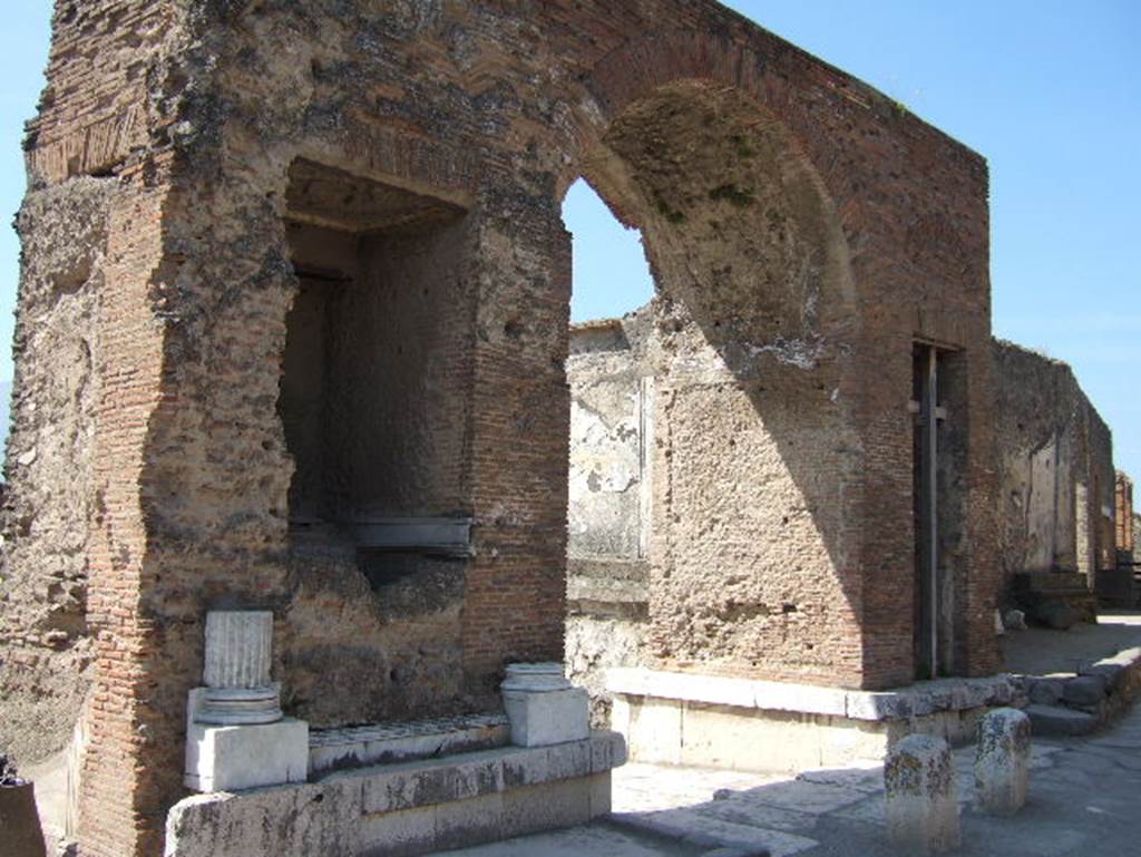 Fountain in arch at north-east corner of Forum. May 2006. Looking south-west.
Nach Eschebach: Die Brunnenbecken am Bogen waren in Gestalt eines Nymphäums mit Grottennischen in Marmor inkrustiert.
According to Eschebach: The fountain basins in the arch were in the form of a nymphaeum with grotto niches clad in marble.
See Eschebach, H., 1983. Pompeii, Herculaneum, Stabiae; Bollettino dell’Associazione Internazionale Amici di Pompei 1, p. 26, fig. 37.