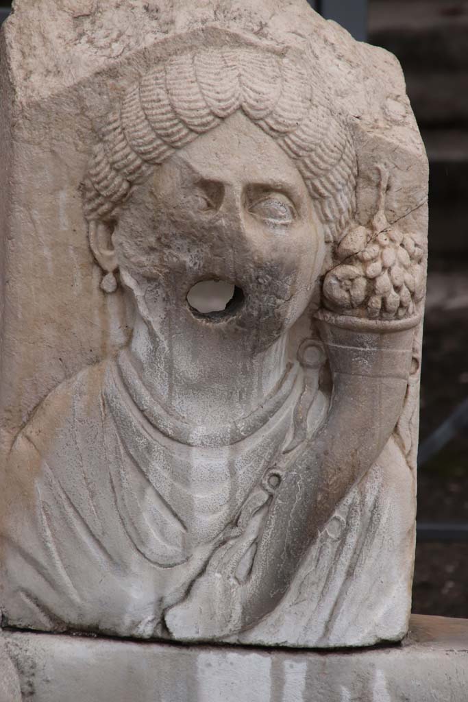 Fountain outside VII.9.67 and VII.9.68. October 2020. Relief of head of Fortuna (Abbondanza) with cornucopia.
Photo courtesy of Klaus Heese.