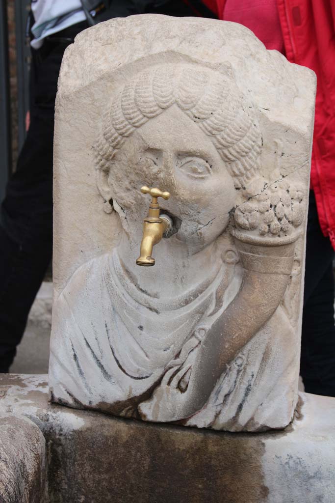 Fountain outside VII.9.67 and VII.9.68. April 2014. Relief of head of Fortuna (Abbondanza) with cornucopia.
Photo courtesy of Klaus Heese.