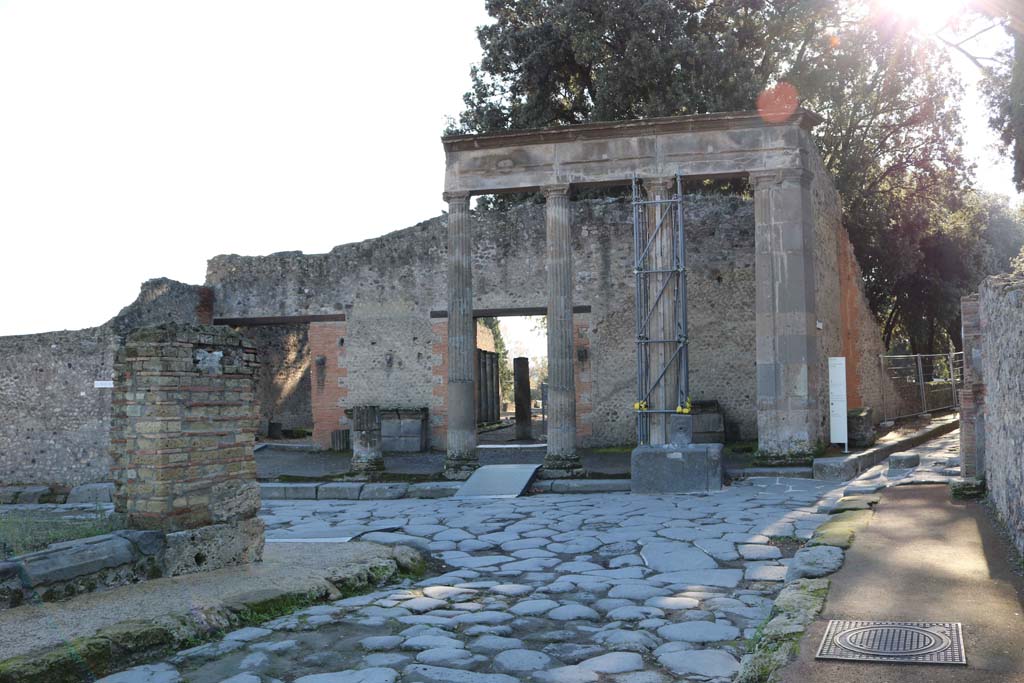 Fountain outside VIII.7.30 Pompeii on Via del Tempio d’Iside. December 2018.
Looking south-east from Via dei Teatri across junction to fountain in Via del Tempio d’Iside. Photo courtesy of Aude Durand.