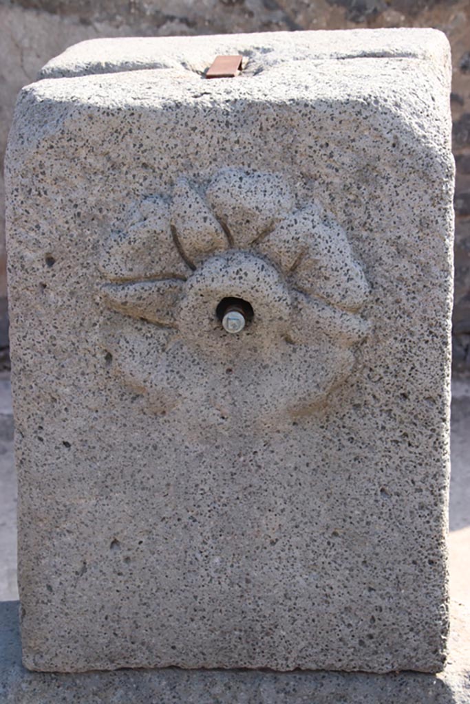 Fountain at IX.8.1, Pompeii. October 2023.
Relief of flower rosette, on pilaster. Photo courtesy of Klaus Heese.
