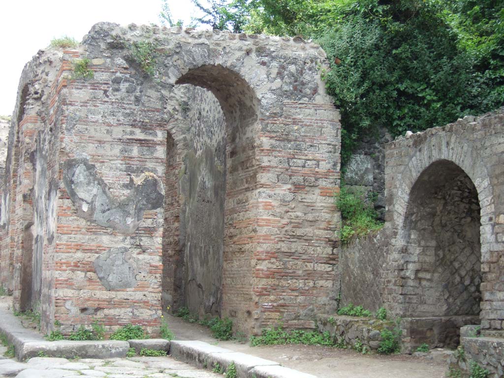 Pompeii Porta Ercolano or Herculaneum Gate. May 2006.
Looking south towards west side from Via dei Sepolcri with Tomb of M. Cerrinius Restitutus, on right.
According to Van der Graaff –
“At the Porta Ercolano, during the excavations next to the Tomb of M. Cerrinius Restitutus, Maiuri recovered a stratum filled with votive offerings including small terracotta vases as well as fragments of figurines………………….
Maiuri ascribed the deposit to a vanished religious sacellum dedicated to Venus or Minerva that was associated with the Samnite gate.
It would have served the gate throughout its history right up to its reconstruction after the earthquake.”
See Van der Graaff, I. (2018). The Fortifications of Pompeii and Ancient Italy. Routledge, (p.211).