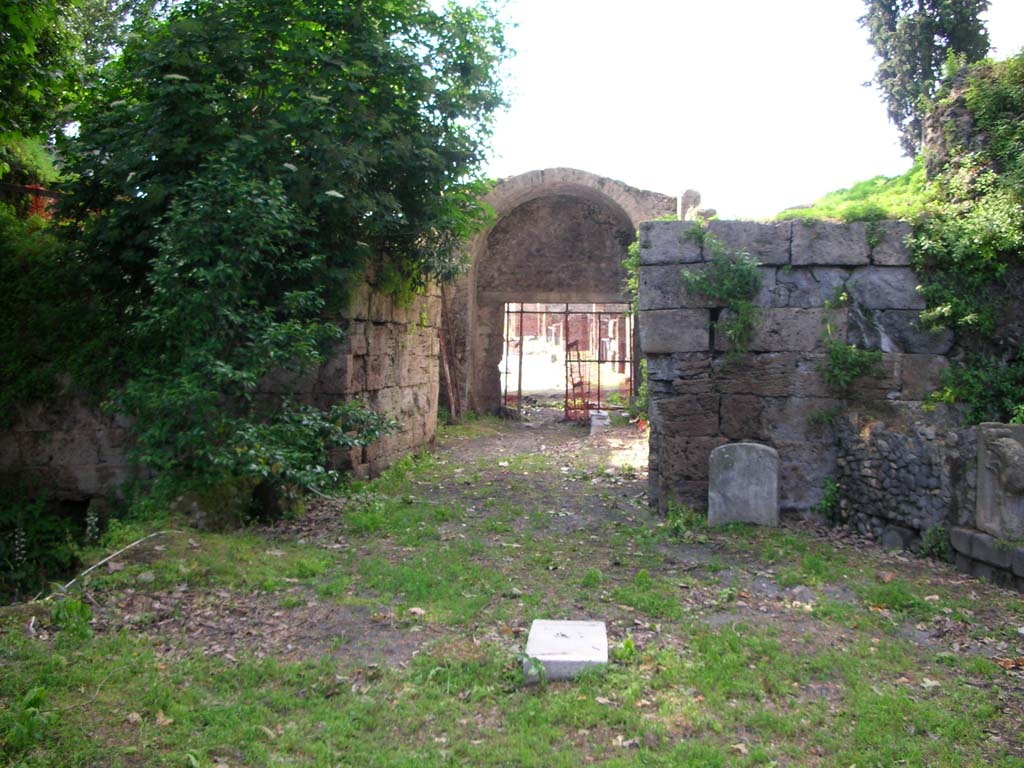 Via Stabiana, Pompeii. May 2010. Looking north through gate from south end, site of bastions. Photo courtesy of Ivo van der Graaff.
According to Van der Graaff –
“The twin bastions at each opening were powerful bulwarks of solid masonry protecting the outer edge of the gates.
Each is composed of travertine ashlars with distinct grooves either facing the inner corners, such as Porta Vesuvio and Stabia, or looking outward, as at Porta Nola. They once accommodated the doors of a simple two-leafed wooden gate that closed the opening. A further gate also marked the threshold on the city side of the gate (Note 33). The overall layout is simple, designed to allow passage through the deep embankment of the agger. It also carried a defensive advantage to trap any attackers in the court of the gate, allowing troops to pelt the enemy from higher ground.”
See Van der Graaff, I. (2018). The Fortifications of Pompeii and Ancient Italy. Routledge, (p.51).