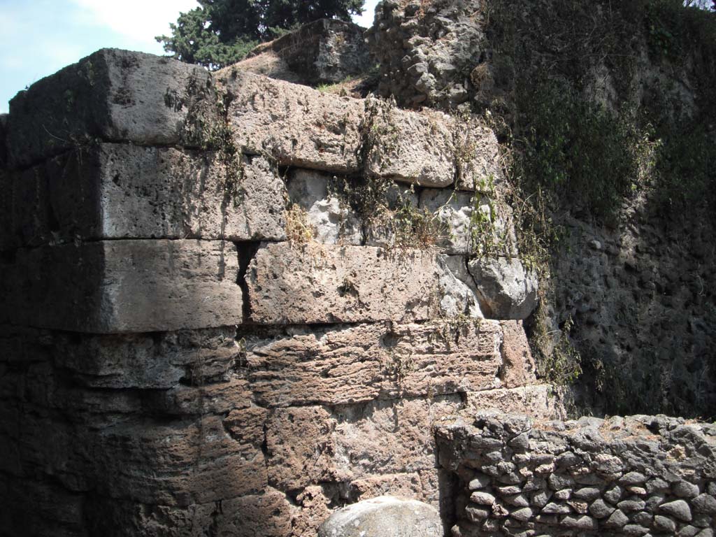 Porta Stabia, Pompeii. May 2011. Detail of south wall on east side. Photo courtesy of Ivo van der Graaff.
According to Van der Graaff-
“The Pompeii Archaeological Research Project: Porta Stabia (PARP:PS), run by the University of Cincinnati, has excavated at the Porta Stabia as part of a wider investigation into the adjacent urban district (see Fig. 1.3). ………………………
The study campaign revised one important element in the construction sequence of the gate.
A comparison between period photographs dating to the turn of the twentieth century against a detailed drawing from Giuseppe Fiorelli published in 1873 attest that a restoration of the gate occurred somewhere between the 1890’s and the 1920’s (Note 86).
The reconstruction included the addition of at least two courses on both bastions, as well as the placing of the spout carved in the shape of a lion head that workers had found nearby. It had vanished by the time Maiuri began his work in the late 1920’s. As a reminder of the reconstruction, the restored courses are composed of a brown tuff stone to serve as a contrast to the lower courses in yellow travertine.”
See Van der Graaff, I. (2018). The Fortifications of Pompeii and Ancient Italy. Routledge, (p.20)