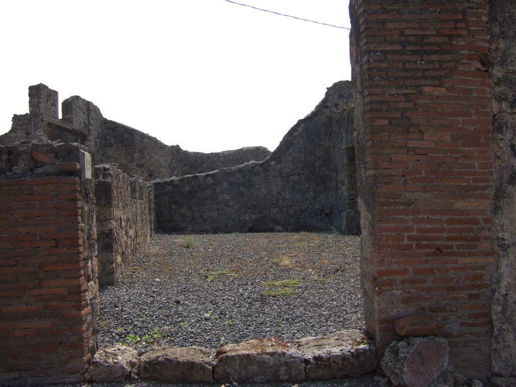 VII.7.19 Pompeii. September 2005. Looking south from entrance directly into atrium.
According to Eschebach, in the middle of the south wall would have been a lararium.
On the left, east side, can be seen doorways to an oecus with stairs to upper floor, and a triclinium fenestratum.
See Eschebach, L., 1993. Gebäudeverzeichnis und Stadtplan der antiken Stadt Pompeji. Köln: Böhlau. (p.302)
According to Boyce –
in the centre of the south wall of the large central room was a rectangular niche (h.0.48, w.0.45, d.0.22, h. above floor 1.65);
in the west wall, near the floor, was an arched niche (h.0.92, w.0.55, d.0.20, h. above floor 0.55).
The latter was called the lararium by Fiorelli, although the former was more like the usual shrine.
See Boyce G. K., 1937. Corpus of the Lararia of Pompeii. Rome: MAAR 14. (p.68, no.300)