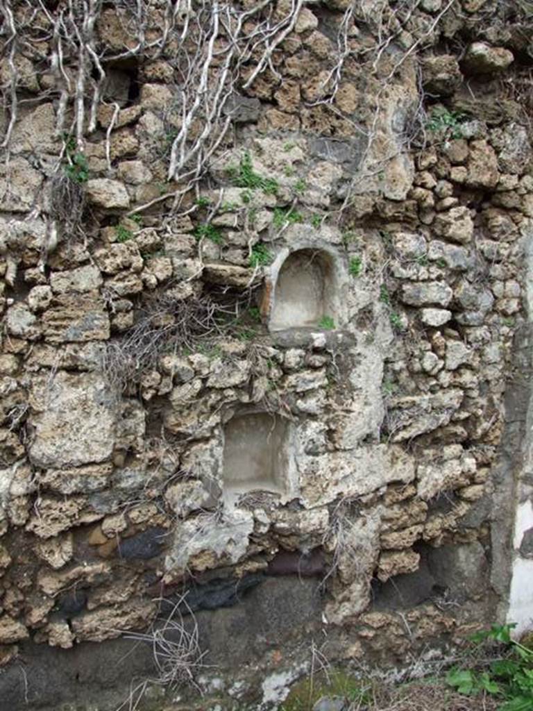 VII.11.14 Pompeii. March 2009. Garden “C”, two small niches on west wall at the north end. According to Boyce, in the same wall to the right of the lararium were set two smaller arched niches. He could not prove whether one or both of these niches had served as a shrine. He thought it was possible that they may have originally been built as lararia and then later been replaced by the large one, described above.
See Boyce G. K., 1937. Corpus of the Lararia of Pompeii. Rome: MAAR 14. (p.70, no.311)