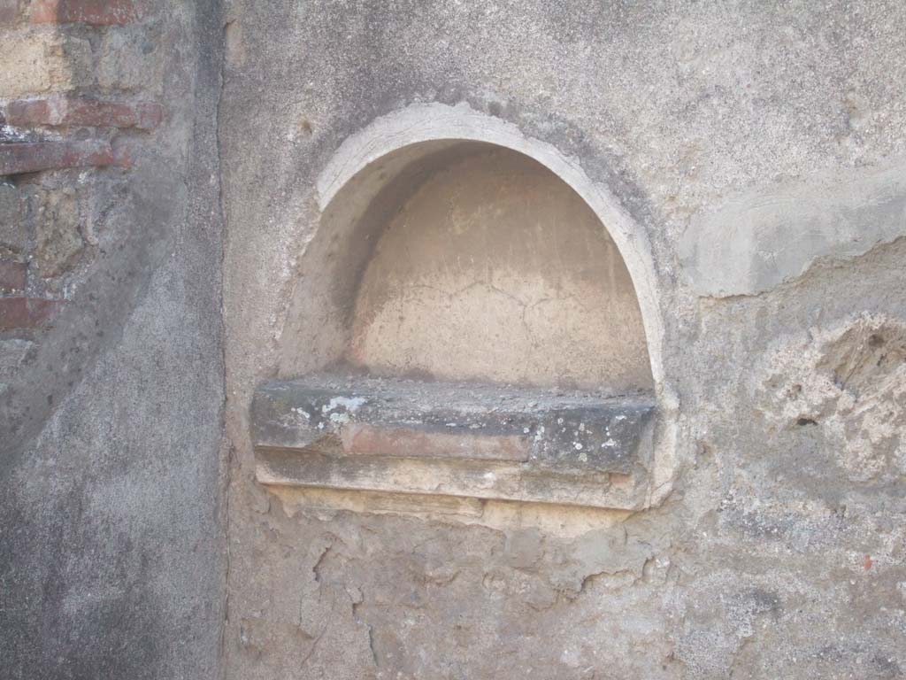 VII.12.15 Pompeii. September 2005. Niche.
According to Boyce –
in the west wall of the bar-room was an arched niche (h.0.38, w.0.69, d.0.20, h. above floor 1.25) with projecting floor.
Below the niche was a stucco cornice.
See Boyce G. K., 1937. Corpus of the Lararia of Pompeii. Rome: MAAR 14. (p.71, no.320)