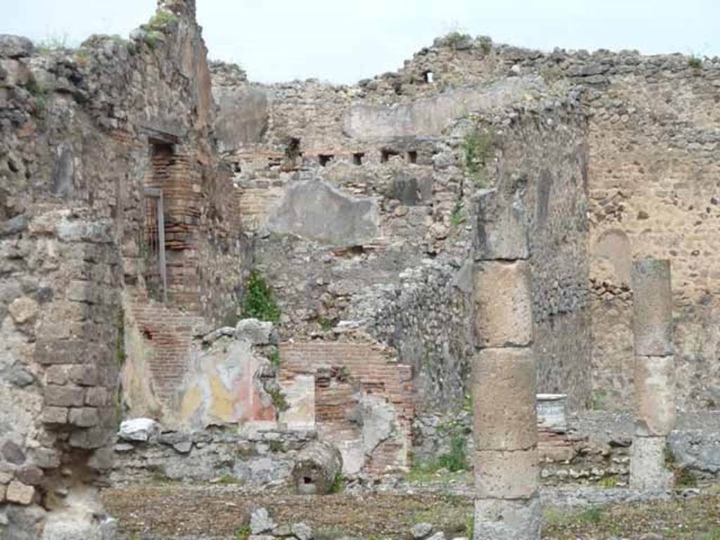VII.13.4 Pompeii. May 2010. North-west corner of peristyle with painted plaster, and rear triclinium room of VII.13.21.
According to Boyce, on the west wall of the peristyle was a rectangular niche (h.0.40, w.0.36, d.0.20, h. above floor 1.60).
Originally this appeared to have been fitted with an aedicula façade but now gone.
The interior walls were coated with white stucco and had delicate decorations in relief.
These included a cornice which ran around the top of the three walls.
See Boyce G. K., 1937. Corpus of the Lararia of Pompeii. Rome: MAAR 14. (p.71 no.323)