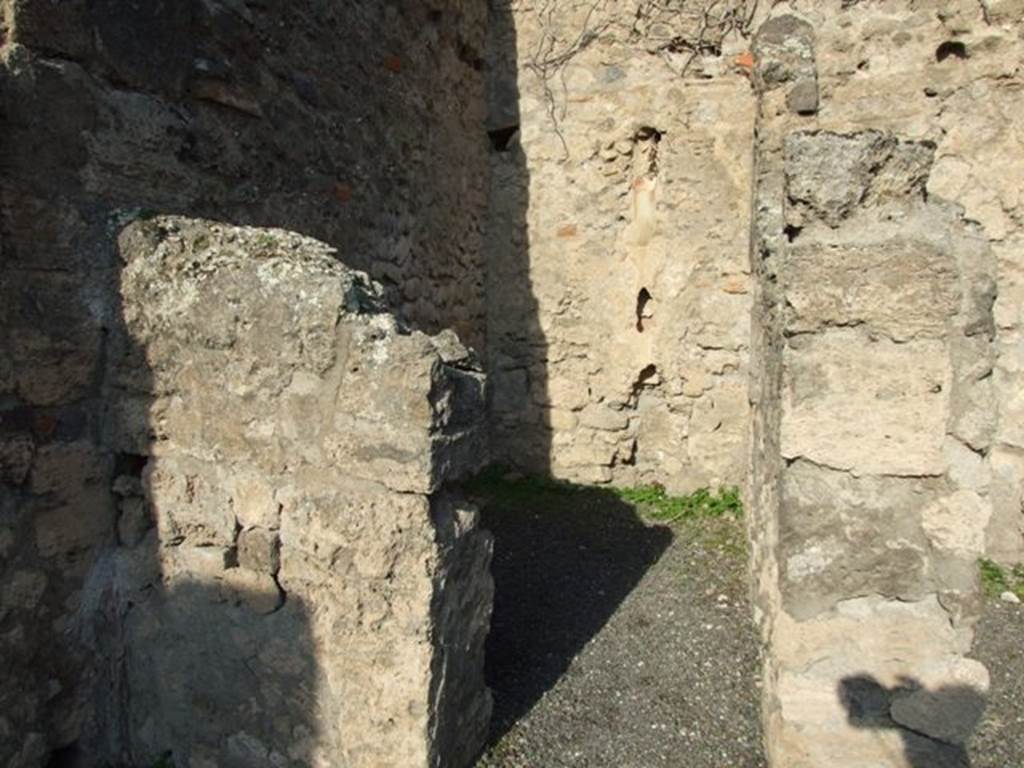 VII.14.2 Pompeii. December 2007. Looking north through doorway to rear room with site of steps to upper floor, and a latrine.
According to Boyce –
a fragmentary painting on the wall of the kitchen appeared to have belonged to a lararium originally painted above it.
Three men (the heads were missing) are busied about a hog: one with staff in his right holds the animal by the ear;
a second drags on a cord tied about its snout. Below lay the carcass of a slaughtered animal, opened as if for divination from the entrails.
He gave the reference – Helbig 83.
See Boyce G. K., 1937. Corpus of the Lararia of Pompeii. Rome: MAAR 14. (p.71, no.325)
