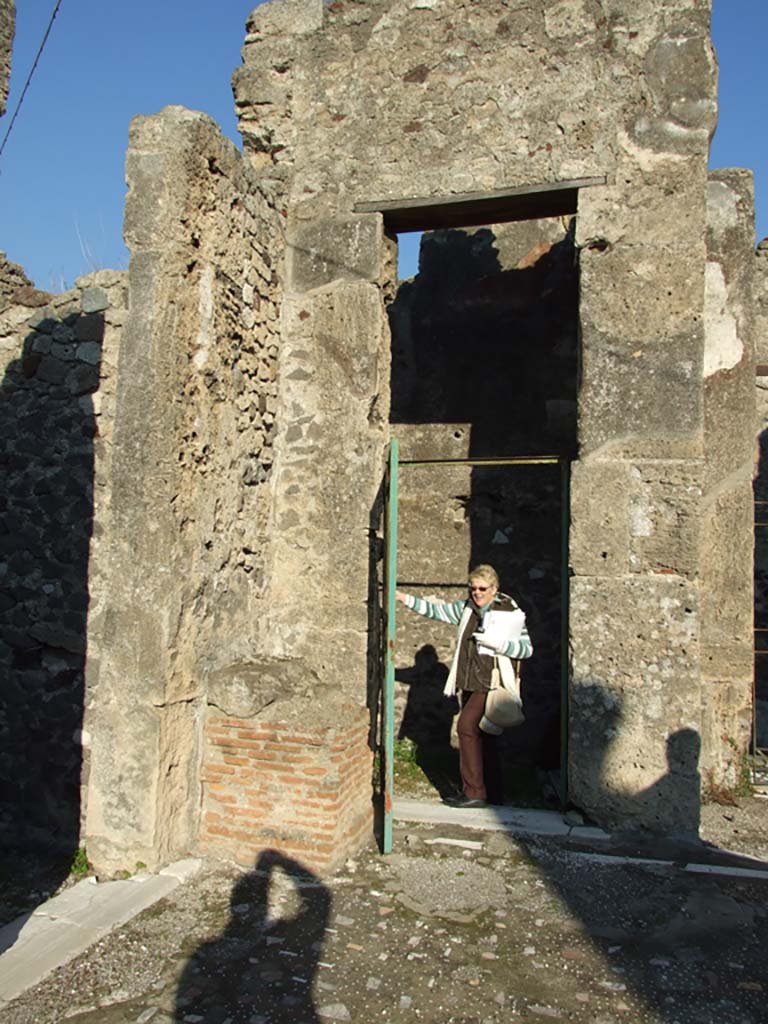 VII.16.13 Pompeii. December 2007. Doorway to room 5, on left, and to room 3, in centre.
Doorway from atrium to rooms 3 and 4 and entrance doorway from VII.16.14.
On the left of the doorway are the remains of the brick base of a shrine to the household gods.
According to Boyce, in the north-east corner of the atrium stood a ruined brick base.
It was later in date than the stucco on the wall and is described by Fiorelli as “l’altare dei sacrifizi”.
Mau described it as “die Basis der Larenkapelle”.
See Boyce G. K., 1937. Corpus of the Lararia of Pompeii. Rome: MAAR 14. (p. 73, no. 340).