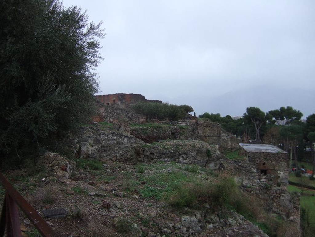 VIII.2.1 Pompeii. December 2005. Looking east from south portico towards VIII.2.3, VIII.2.14, VIII.2.16. The area on the left of the photo, would have been the approximate area of the sacrarium. The south portico is the limit of the upper floor, and all rooms to the south have collapsed.