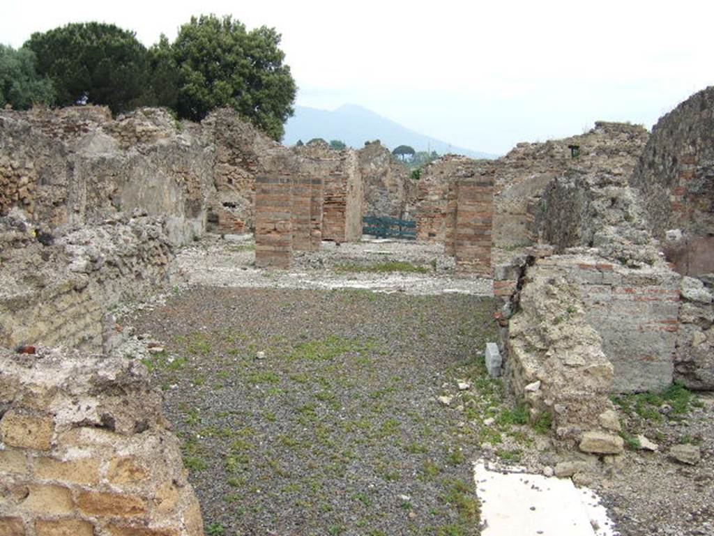 VIII.2.29 Pompeii. September 2005. Looking north across tablinum to atrium and entrance doorway.
In the north-west corner of the atrium would have been a masonry lararium, (in the area to the left of the brick pilasters).
According to Boyce, this lararium was later in date than the stucco of the walls of the room. The walls were in the IVth Style.
Around the base of the lararium ran a dado of marble.
In this corner of the atrium the black border in the mosaic pavement was made to run around the two sides of the podium.
This marked its position.
According to Mau, some other object stood here before the construction of the lararium.
These would have been either the arca for the money, or a smaller and more modest lararium, which was then enlarged.
See Notizie degli Scavi di Antichità, 1883, 135. Bull. Inst, 1885, pp.88, 93.
See Boyce G. K., 1937. Corpus of the Lararia of Pompeii. Rome: MAAR 14. (p.74, no. 346)
According to Giacobello, only the podium survives of the aedicula in the north-west corner of the atrium.
See Giacobello, F., 2008. Larari Pompeiani: Iconografia e culto dei Lari in ambito domestico. Milano: LED Edizioni. (p.247, no.A32)