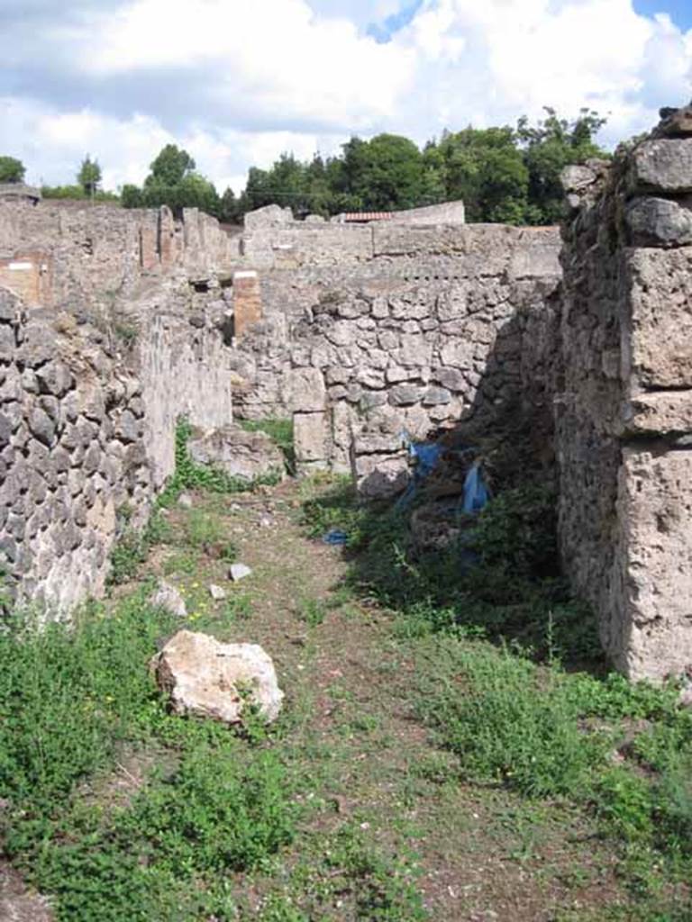 VIII.7.10 Pompeii. September 2010.
Looking east from garden area towards kitchen, and blocked doorway to corridor leading to entrance on Via Stabiana.
In the south wall (on the right in the shadow) appears to show the remains of a niche, perhaps with a shelf below protruding from the wall.
Photo courtesy of Drew Baker.
According to Boyce (described as VIII.viii.10) –
“In the wall of the kitchen there was a niche and beside it was a lararium painting.
It represented a sacrificial scene with the Genius and the tibicen, one on each side of an altar. On either side of them was a Lar.
In the lower zone was a single serpent beside an altar.
See Boyce G. K., 1937. Corpus of the Lararia of Pompeii. Rome: MAAR 14. (p.78, no.377).
See Sogliano, A., 1879. Le pitture murali campane scoverte negli anni 1867-79. Napoli: (p.12, no.24, “badly preserved”).
According to Mau -
“Next to the hearth there was the usual painting of the Lares, and a niche.”
See Mau in BdI, 1875, (p.167) (p.166-169 - La quarta casa).
