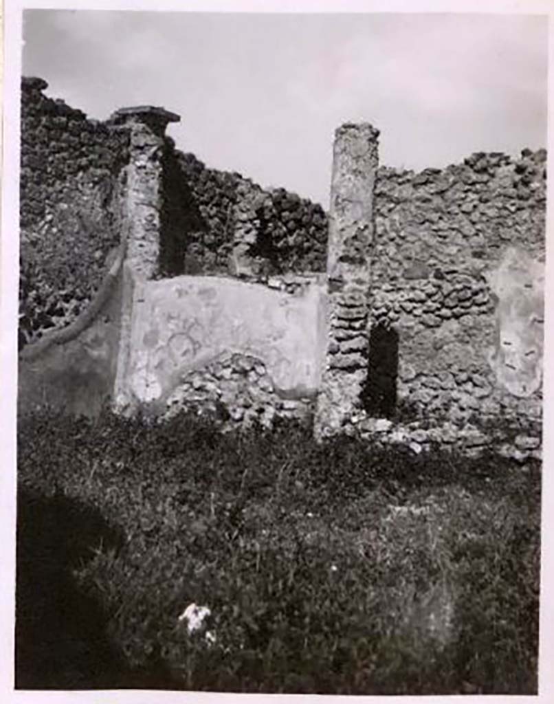 IX.2.17 Pompeii. Pre-1943. Room 9, north wall at west end of garden area. Photo by Tatiana Warscher.
See Warscher, T. Codex Topographicus Pompeianus, IX.2. (1943), Swedish Institute, Rome. (no.93.), p. 173.
According to Boyce, the two columns at the west end of the north row were connected by a low wall.
On the south side of this wall, facing the open area, was painted in red a simple aedicula with pediment.
Within the aedicula were painted two yellow serpents confronted at an altar.
See Boyce G. K., 1937. Corpus of the Lararia of Pompeii. Rome: MAAR 14. (p. 81, no. 397).