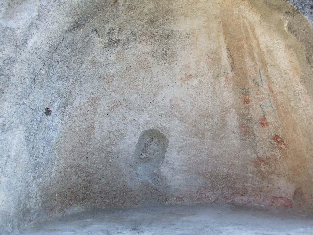 IX.3.2 Pompeii. March 2009. Garden area. Niche in south wall. The niche was originally decorated with yellow, red and green flowers.
See Giacobello, F., 2008. Larari Pompeiani: Iconografia e culto dei Lari in ambito domestico. Milano: LED Edizioni. (p.284, no.V78).
According to Boyce, in the south wall of the peristyle is a vaulted semi-circular niche (h.0.48, w.0.62, d.0.35, h. above floor 1.65).
The inside walls were decorated on a white background with red and yellow spots and outlined with red stripes.
The two Lares were painted on the wall above the niche and below it the serpents, confronted at an altar.
Bronze statues were found in the niche on 12th July 1847: a female figure, a male figure, Hercules, Jupiter, and Isis-Fortuna.
See Boyce G. K., 1937. Corpus of the Lararia of Pompeii. Rome: MAAR 14. (p. 82, no. 406, Pl. 4, 2.)
Helbig also gave a description of the statuettes found in the niche:
See Helbig, W., 1868. Wandgemälde der vom Vesuv verschütteten Städte Campaniens. Leipzig: Breitkopf und Härtel. (69b)