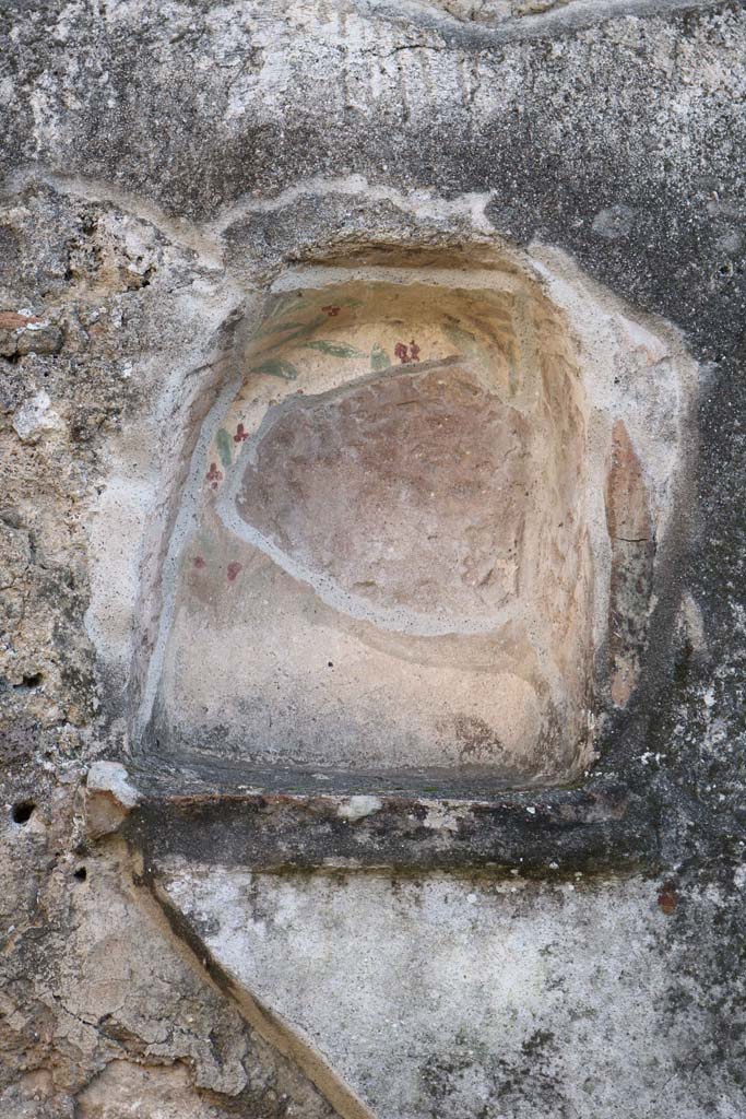 IX.3.12 Pompeii. December 2018. Niche set into south wall. Photo courtesy of Aude Durand.
According to Boyce –
the niche (h.0.45, w.0.38, d.0.25, h. above floor 1.60) was adorned inside with painted plants, having green and brown leaves and red flowers.
On the white plaster surrounding the niche, there were paintings of figures.
See Boyce G. K., 1937. Corpus of the Lararia of Pompeii. Rome: MAAR 14. (p.83 no. 409 and Pl.26,1).