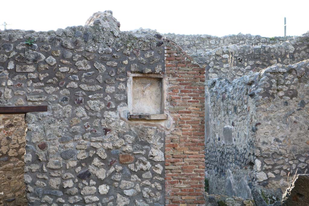 IX.3.20 Pompeii. December 2018. Room 1, looking towards west wall with niche. Photo courtesy of Aude Durand.
According to Boyce, this rectangular niche with ledge had a lararium painting on the wall at its side.
The Genius with the assistance of tibicen and camillus performed a sacrifice at the altar.
The Camillus was very small and carried an urceus in one hand and a patera in the other.
A Lar stood on each side.
Below, a single serpent approached an altar complete with offerings.
See Boyce G. K., 1937. Corpus of the Lararia of Pompeii. Rome: MAAR 14. (p. 84, 417)
See Pappalardo, U., 2001. La Descrizione di Pompei per Giuseppe Fiorelli (1875). Napoli: Massa Editore. (p. 147)
See Trendelenburg in Bullettino dell’Instituto di Corrispondenza Archeologica (DAIR), 1871, p.207.