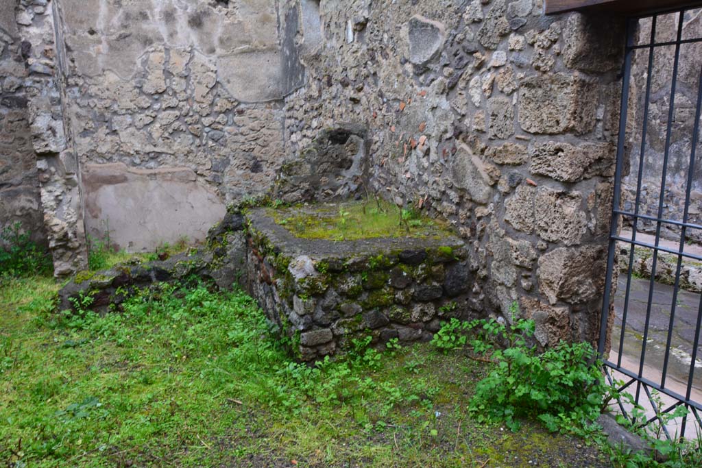 IX.5.11 Pompeii. March 2017. Room r, looking north-east towards hearth, with doorway at IX.5.13, on right.
Foto Christian Beck, ERC Grant 681269 DÉCOR.
According to Boyce –
In the kitchen entered from the east side of the peristyle and having separate communication with the street at IX.5.13, in the north wall is a rectangular niche (h.0.40, w.0.45, d.0.20, h. above floor 0.95), and on the wall beside it are faint traces of the original lararium painting.
He gives the reference - Bull. Inst. 1879, p.195, which says - .
“Fra l’ingresso e il focolare evvi nel muro nord la nicchia de’Lari e deboli tracce della pittura lararia”.
(Between the entrance and the hearth, there is in the north wall faint traces of the niche of the Lares and lararium painting).
See Boyce G. K., 1937. Corpus of the Lararia of Pompeii. Rome: MAAR 14. (p.86, no.424).
(Note: it looks like the north wall at rear of the hearth has fallen).
).