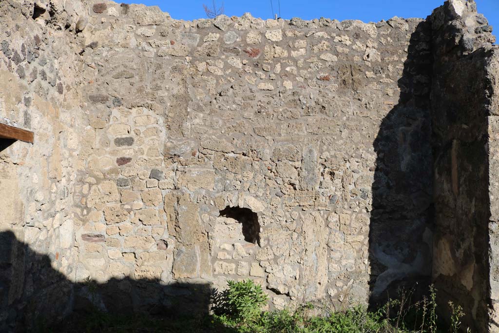 IX.6.e Pompeii. December 2018. East wall with niche. Photo courtesy of Aude Durand.
According to Boyce, in the east wall of the taberna was a rectangular niche (h.0.48, w.0.43, d.0.24, h. above floor 1.10) with peaked ceiling.
Its walls were coated with white stucco outlined in red.
Around it on the wall was a lararium painting, of which only a cornucopia on the left side could be seen when excavated.
See Boyce G. K., 1937. Corpus of the Lararia of Pompeii. Rome: MAAR 14. (p.87, no.433)
According to Sogliano, in the shop a sacred picture was found.
See Notizie degli Scavi di Antichità, 1879, p. 72.
See Sogliano, A., 1879. Le pitture murali campane scoverte negli anni 1867-79. Napoli: (p. 19, no. 71)