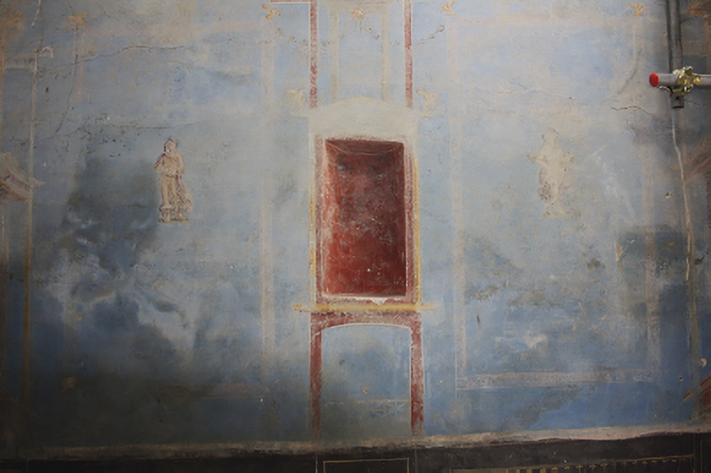IX.10 Pompeii. House on west side of insula, south of IX.10.1. June 2024. Sacrarium room 32 west wall with blue decoration, showing niche in red with figures either side.
On the left is the divinity of Summer. On the right is the divinity of Winter.
A similar pattern exists on the east wall with representations of the divinities of Autumn and Spring.
See PAP 15-E-Journal-Sacrario-Regio-IX.pdf, fig. 12. p. 12,
See also photos in the E-Journal (pages 12 and 13) of: Summer – fig. 20, Winter – fig. 21, Autumn - fig. 22 and Spring - fig. 23.
Photograph © Parco Archeologico di Pompei.