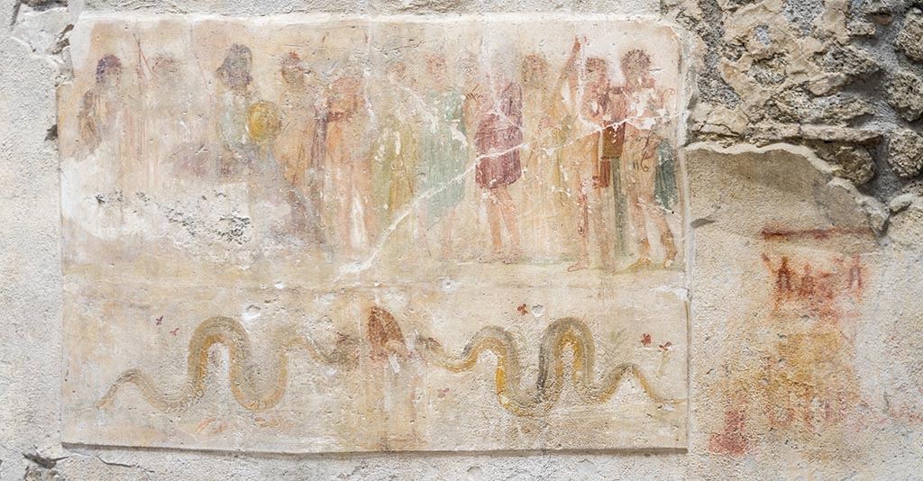 IX.12.6 Pompeii. July 2024.
Room “n1”, lararium painting on west wall, showing Hercules being presented to the twelve gods in the upper part.
Underneath are two serpents approaching an altar.
To the right are the remains of a possible preparatory sketch for a lararium painting?
Photo courtesy of Johannes Eber.