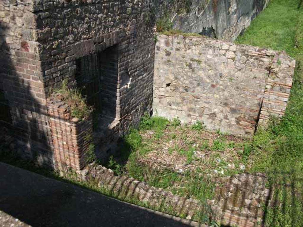 HGW24 Pompeii. May 2010. Room in south-west corner of garden area.
According to Garcia y Garcia, a bomb was dropped here during the night of 18th September 1943.
This bomb fell on the south-west corner of the peristyle causing the destruction of part of the wall south of the turret and the collapse of the rear slope.
It was restored in 1946.
See Garcia y Garcia, L., 2006. Danni di guerra a Pompei. Rome: L’Erma di Bretschneider. (p.160-1)
According to Boyce, a small room opened off the south-west corner of the large portico surrounding the garden.
This room had a semi-circular niche in the east wall. The room was called a lararium in the reports.
See Boyce G. K., 1937. Corpus of the Lararia of Pompeii. Rome: MAAR 14. (p.97, no.478).
(Fontaine, room 5,2).