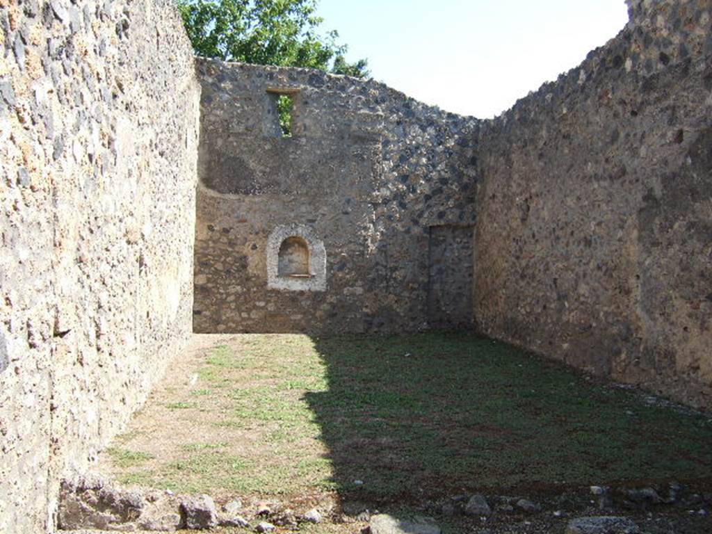 I.11.13 Pompeii. September 2005. Looking east across garden area.
According to Jashemski, the garden had a portico on the west (nearest) side supported by one column. A low wall separated the garden from the portico. There is an arched niche Lararium on the east wall. See Jashemski, W. F., 1993. The Gardens of Pompeii, Volume II: Appendices. New York: Caratzas. (p.52) Neither the one column on the portico nor the low wall appear to be there anymore.